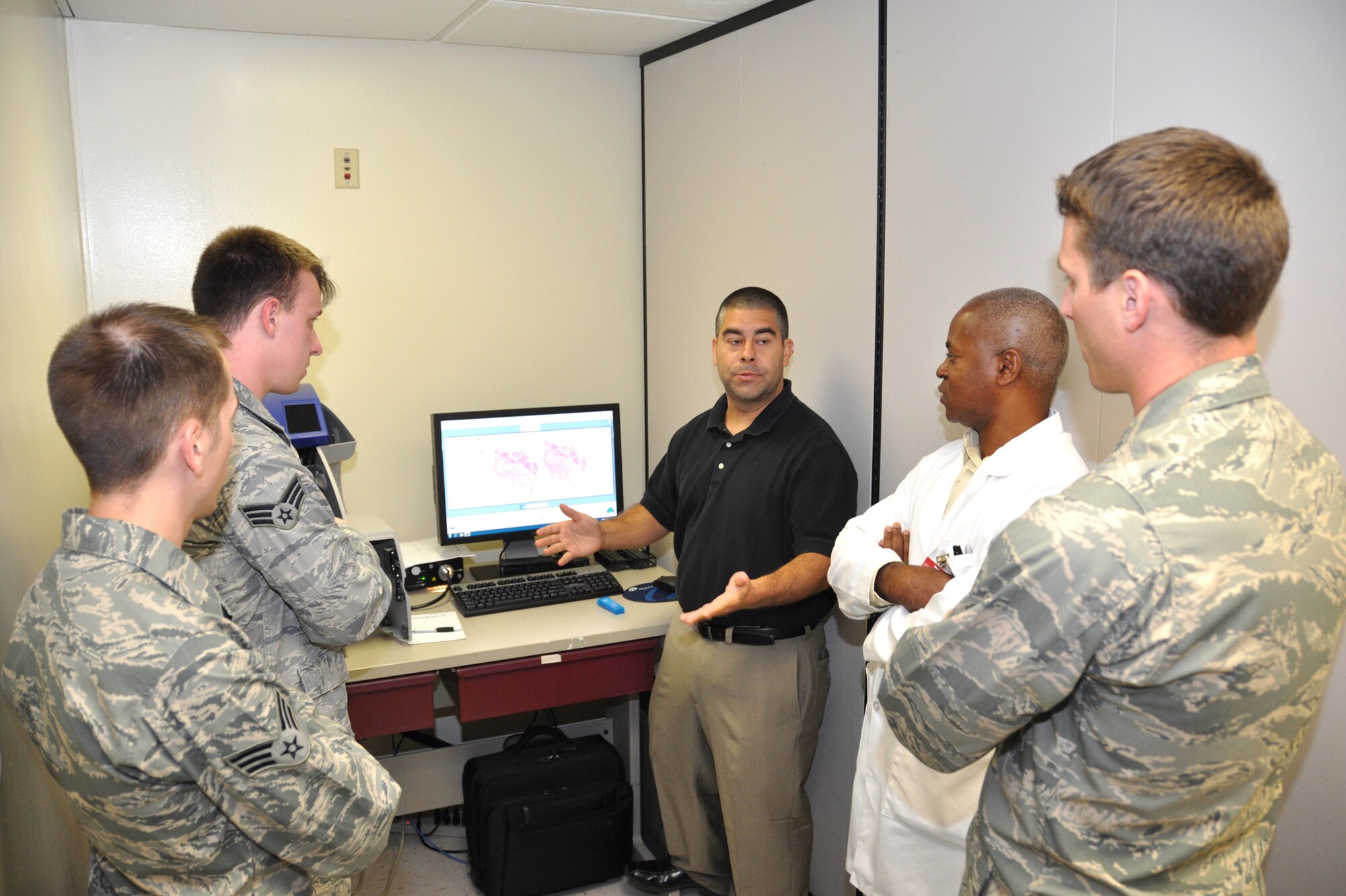 Technician Adam Schiffer, center, Aperio’s field services regional supervisor, shows, 81st Diagnostics and Therapeutics Squadron members, from left, lab technicians Senior Airmen Quinton Moll and Johnathon Skrocki, anatomic pathology supervisor Terry Augustine and medical director for microbiology and director of telepathology Maj. (Dr.) Nicholas Lancia the basic software that drives the scanner June 14, 2012, at the Keesler Hospital, Keesler Air Force Base, Miss. He also explained some of the basic errors they might encounter and how to fix them.  (U.S. Air Force photo by Steve Pivnick)