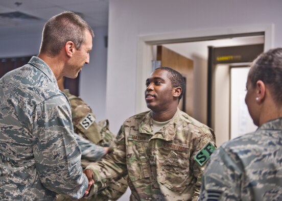 U.S. Air Force Col. Paul Kasuda, 820th Base Defense Group commander, gives a farewell hand-shake to Senior Airman Hakim Madyun from the 440th Security Forces Squadron at Pope Air Force Base, N.C., before departing for a six-month deployment to Afghanistan, June 26, 2012, at Moody Air Force Base, Ga. Madyun was among many other Airmen from different bases who left that day to support members of Moody’s 824th Base Defense Squadron. (U.S. Air Force photo by Senior Airman Eileen Meier/Released)