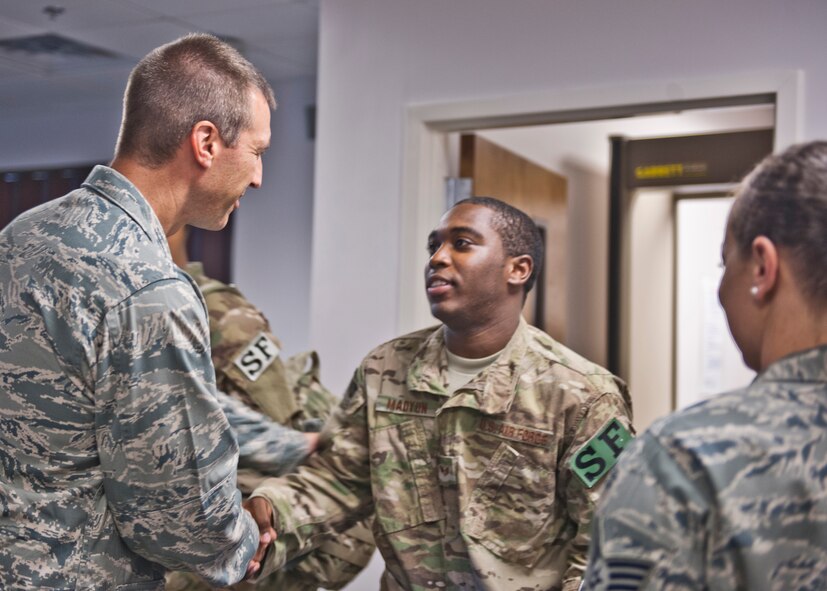 U.S. Air Force Col. Paul Kasuda, 820th Base Defense Group commander, gives a farewell hand-shake to Senior Airman Hakim Madyun from the 440th Security Forces Squadron at Pope Air Force Base, N.C., before departing for a six-month deployment to Afghanistan, June 26, 2012, at Moody Air Force Base, Ga. Madyun was among many other Airmen from different bases who left that day to support members of Moody’s 824th Base Defense Squadron. (U.S. Air Force photo by Senior Airman Eileen Meier/Released)