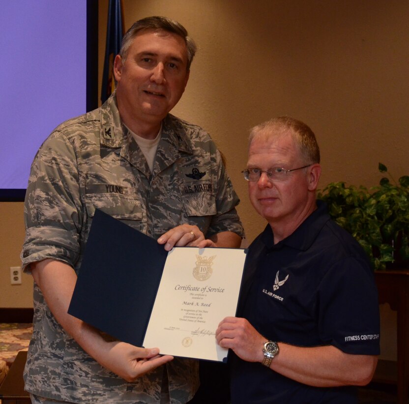 Mark A. Reed recieves the 10 year service award from Colonel Darrell G. Young commander, 934th Airlift Wing during civilian commanders call at the Services club. Minneapolis-St. Paul Air Reserve Station, Minn. (U.S. Air Force photo by Tech. Sgt. Bob Sommer)