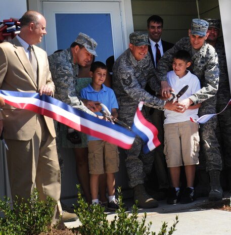 John Hoyt, Forest City Development vice president, Maj. General Timothy Byers, The Civil Engineer, Headquarters Air Force, Washington, D.C., Tara Bradford and husband Tech. Sgt. Michael Bradford, 628th Civil Engineer Squadron, John Ehle, Forest City Communities senior vice president, Brig. Gen. Timothy Green, Director of Installations and Mission Support, Headquarters Air Mobility Command and Col. Richard McComb, Joint Base Charleston commander, join the Bradfords and their children as they cut the ribbon during a ceremony for the newly built privatized housing at Joint Base Charleston- Air Base June 27, 2012.  (U.S. Air Force photo/Airman 1st Class Ashlee Galloway)