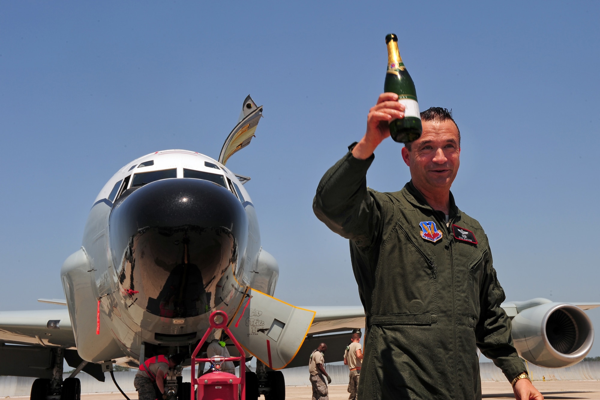 U.S. Air Force Brig. Gen. Donald Bacon, 55th Wing Commander, salutes the men and women attending his fini flight after being hosed down with a fire hose and champagne bottles from family and aircrew June 26 at Offutt Air Force Base, Neb.  Fini flights are a common military tribute to the outgoing commander of a military instillation.  (U.S. Air Force photo by Josh Plueger/Released)