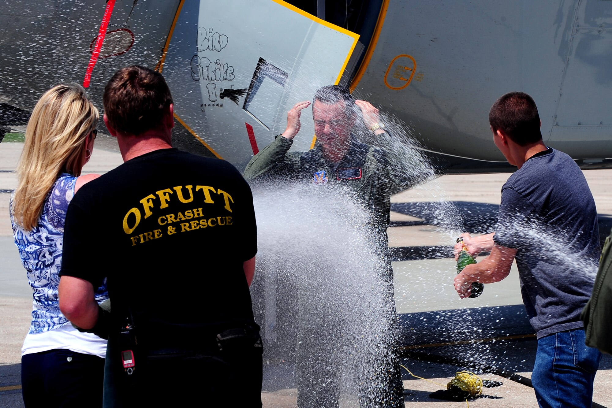 U.S. Air Force Brig. Gen. Donald Bacon, 55th Wing Commander, get hosed down by his wife and son following his fini flight, symbolizing the end of his command June 26 at Offutt Air Force Base, Neb. The "Fini Flight" is a military tradition where a commander gets hosed down by family and aircrew members on their final flight with the wing prior to relinquishing command.  (U.S. Air Force photo by Josh Plueger/Released)