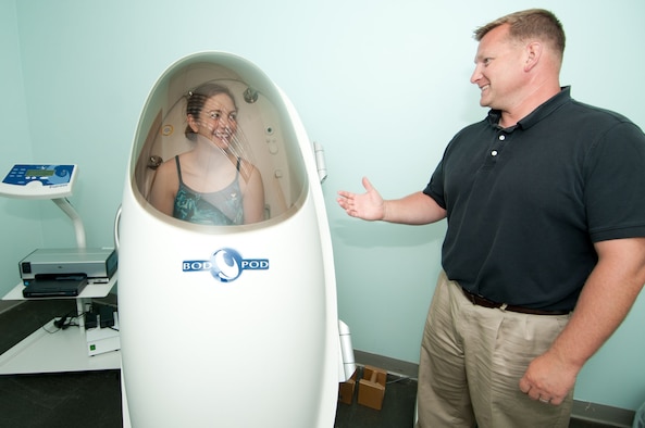 HANSCOM AIR FORCE BASE, Mass. – Lt. Michelle Harrington listens to instructions from Dale Bennett, exercise physiologist, as she sits in the Bod Pod at the Health and Wellness Center. The Bod Pod, which measures body composition by using air displacement technology, is one of many health and wellness initiatives the HAWC offers to the Hanscom community at no cost. (U.S. Air Force photo by Rick Berry)
