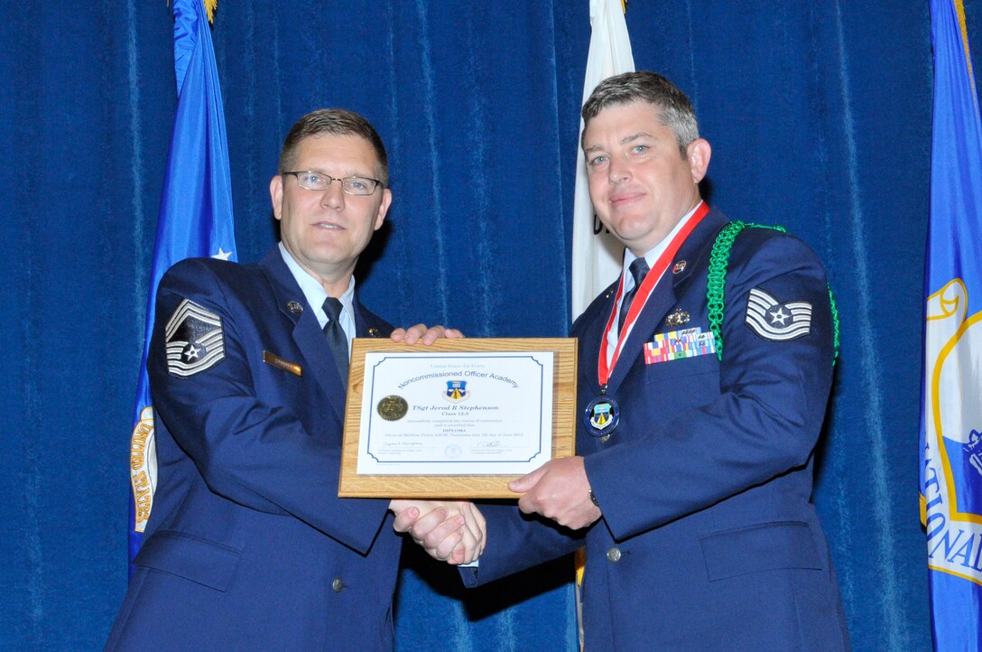 McGHEE TYSON AIR NATIONAL GUARD BASE, Tenn. - Tech. Sgt. Jerod Stephenson, right, receives the distinguished graduate award for NCO Academy Class 12-5 at the I.G. Brown Training and Education Center here from Chief Master Sgt. Thomas K. Stoudt, June 7, 2012.  The distinguished graduate award is presented to students in the top ten percent of the class.  It is based on objective and performance evaluations, demonstrated leadership, and performance as a team player. (Air National Guard photo by Master Sgt. Kurt Skoglund/Released)