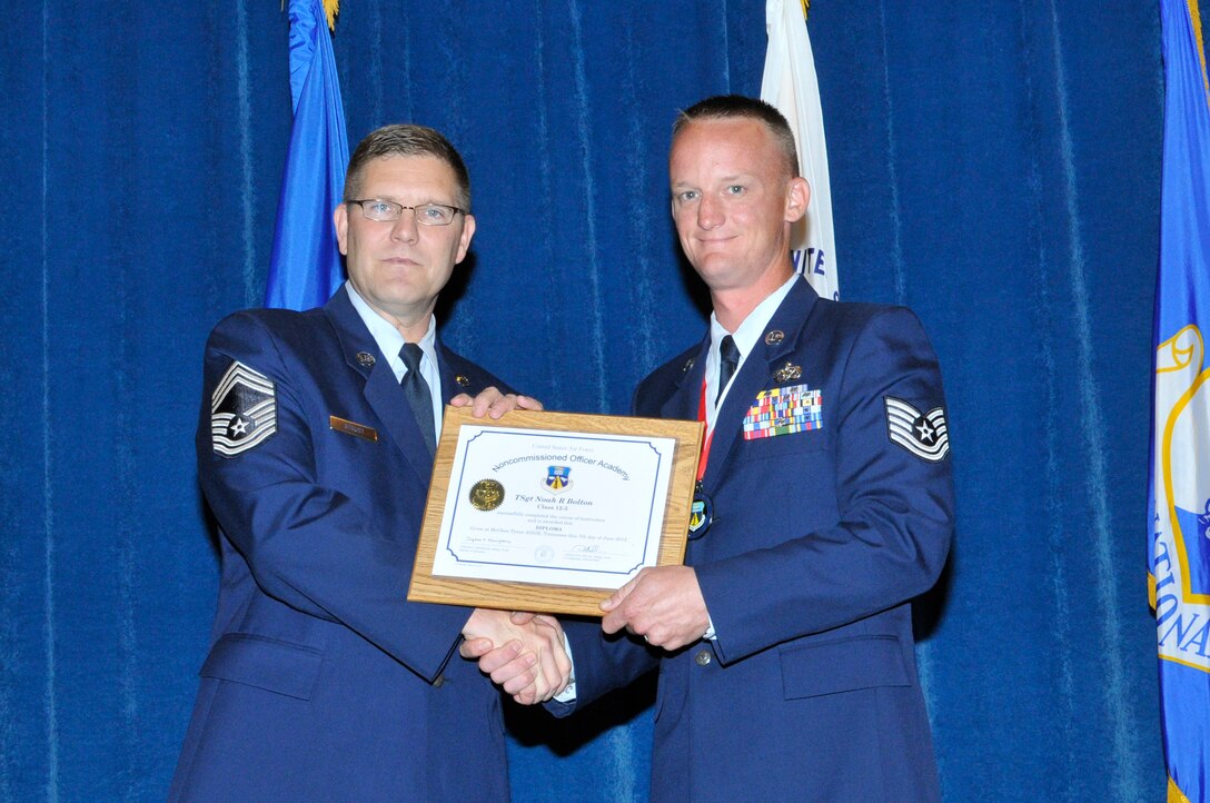 McGHEE TYSON AIR NATIONAL GUARD BASE, Tenn. - Tech. Sgt. Noah Bolton, right, receives the distinguished graduate award for NCO Academy Class 12-5 at the I.G. Brown Training and Education Center here from Chief Master Sgt. Thomas K. Stoudt, June 7, 2012.  The distinguished graduate award is presented to students in the top ten percent of the class.  It is based on objective and performance evaluations, demonstrated leadership, and performance as a team player. (Air National Guard photo by Master Sgt. Kurt Skoglund/Released)