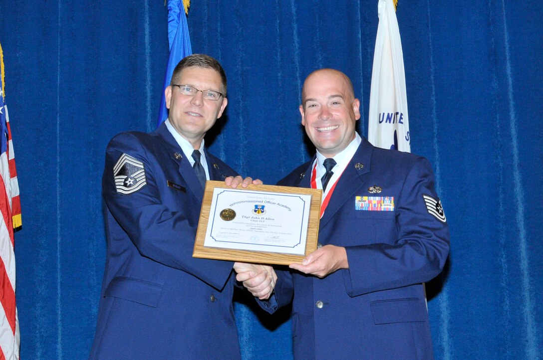 McGHEE TYSON AIR NATIONAL GUARD BASE, Tenn. - Tech. Sgt. John Allen, right, receives the distinguished graduate award for NCO Academy Class 12-5 at the I.G. Brown Training and Education Center here from Chief Master Sgt. Thomas K. Stoudt, June 7, 2012.  The distinguished graduate award is presented to students in the top ten percent of the class.  It is based on objective and performance evaluations, demonstrated leadership, and performance as a team player. (Air National Guard photo by Master Sgt. Kurt Skoglund/Released)