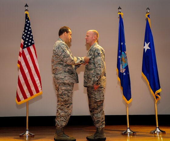 Staff Sgt. Douglas Ryan, 628th Explosive Ordnance Disposal noncommissioned officer in charge of training, stands at attention while Maj. Gen. Timothy Byers, the Air Force Civil Engineer, pins on one of his two medals he received June 27 at the Joint Base Charleston Theater. Ryan deployed once to Iraq and twice to Afghanistan. In addition to the Air Force Combat Action Medal and Bronze Star, he has also received the Army Combat Action Badge and the Navy/Marines Corps Combat Action Ribbon as well as multiple Army Commendation medals. (U.S. Air Force photo by Airman 1st Class Chacarra Walker/Released)
