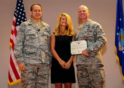 Major Gen. Timothy Byers, the Air Force Civil Engineer, Staff Sgt. Douglas Ryan, 628th Explosive Ordnance Disposal noncommissioned officer in charge of training and his wife Becka Ryan pose for a photo after Ryan was presented with the Air Force Combat Action Medal and the Bronze Star Medal June 27 at the Joint Base Charleston Theater. Ryan deployed once to Iraq and twice to Afghanistan. In addition to the Air Force Combat Action Medal and Bronze Star, he has also received the Army Combat Action Badge and the Navy/Marines Corps Combat Action Ribbon as well as multiple Army Commendation medals. (U.S. Air Force photo by Airman 1st Class Chacarra Walker/Released)