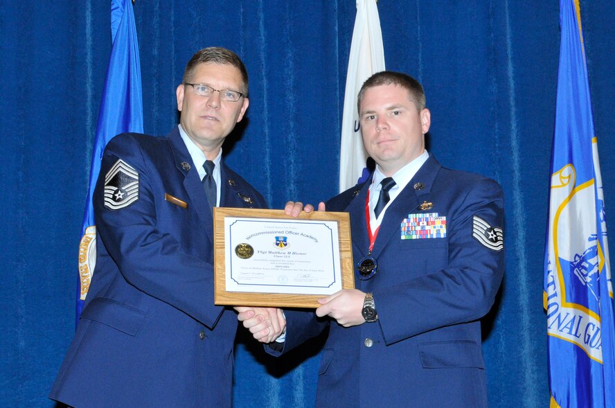 McGHEE TYSON AIR NATIONAL GUARD BASE, Tenn. - Tech. Sgt. Matthew Hivner, right, receives the distinguished graduate award for NCO Academy Class 12-5 at the I.G. Brown Training and Education Center here from Chief Master Sgt. Thomas K. Stoudt, June 7, 2012.  The distinguished graduate award is presented to students in the top ten percent of the class.  It is based on objective and performance evaluations, demonstrated leadership, and performance as a team player. (Air National Guard photo by Master Sgt. Kurt Skoglund/Released)