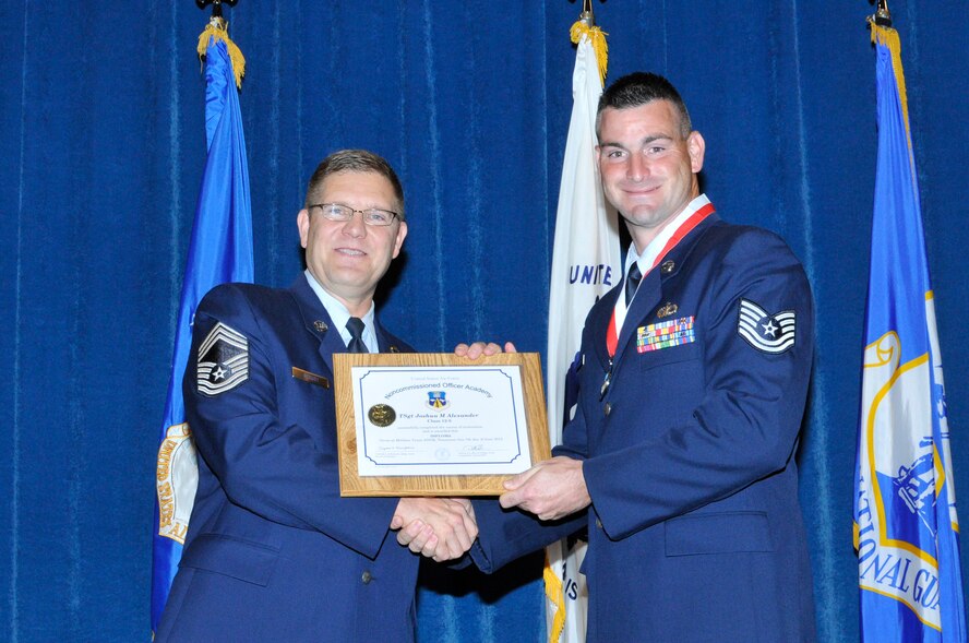 McGHEE TYSON AIR NATIONAL GUARD BASE, Tenn. - Tech. Sgt. Joshua Alexander, right, receives the distinguished graduate award for NCO Academy Class 12-5 at the I.G. Brown Training and Education Center here from Chief Master Sgt. Thomas K. Stoudt, June 7, 2012.  The distinguished graduate award is presented to students in the top ten percent of the class.  It is based on objective and performance evaluations, demonstrated leadership, and performance as a team player. (Air National Guard photo by Master Sgt. Kurt Skoglund/Released)