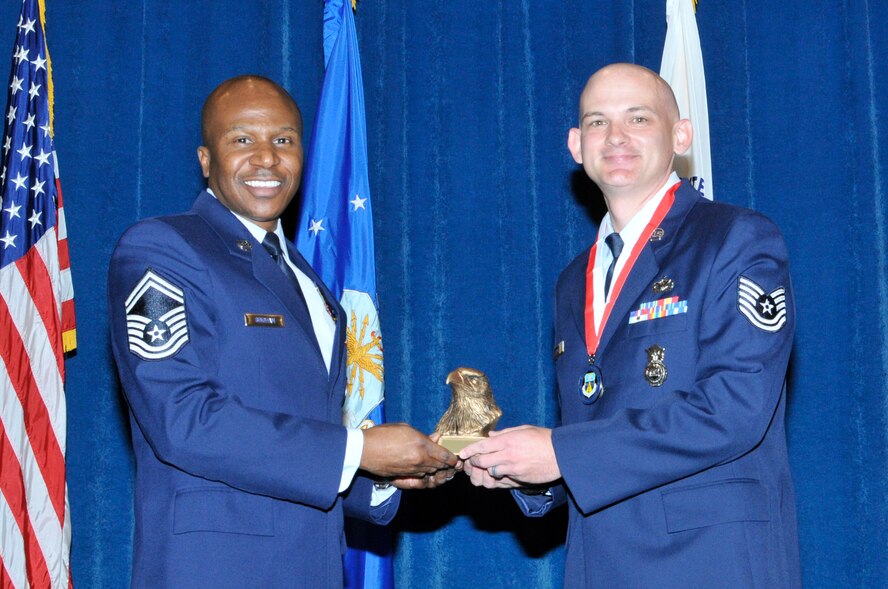 McGHEE TYSON AIR NATIONAL GUARD BASE, Tenn. - Tech. Sgt. Christopher Bemboom, right, receives the academic achievement award for NCO Academy Class 12-5 at the I.G. Brown Training and Education Center here from Senior Master Sgt. Tyrone Bingham, left, EPME Director of Education, June 7, 2012.  The academic achievement award denotes excellence as a scholar.  It is based upon all summative objective tests and individual performance evaluations and is given to the student with the highest overall academic standing. (Air National Guard photo by Master Sgt. Kurt Skoglund/Released)