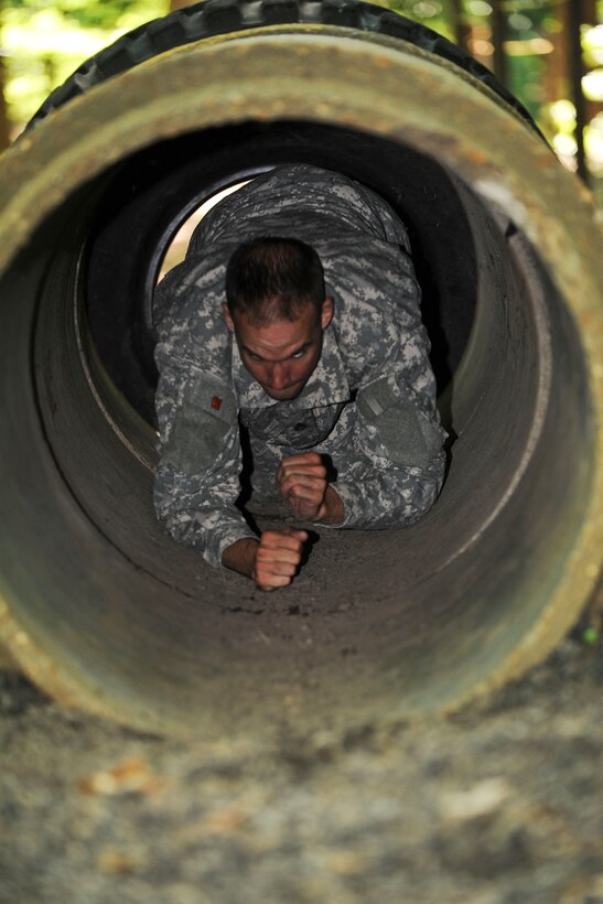 U.S. Army Staff Sgt. Jarod Moss, 95th Reserve Division drill sergeant, crawls through the tunnel obstacle on the confidence course at Fort Eustis, Va., as part of the annual Drill Sergeant of the Year competition, hosted by Initial Military Training, U.S. Army Training and Doctrine Command, June 27, 2012. During the course competitors had to do things like; low crawl, cross monkey bars, climb walls and jump ditches. (U.S. Air Force photo by Senior Airman Wesley Farnsworth/Released)