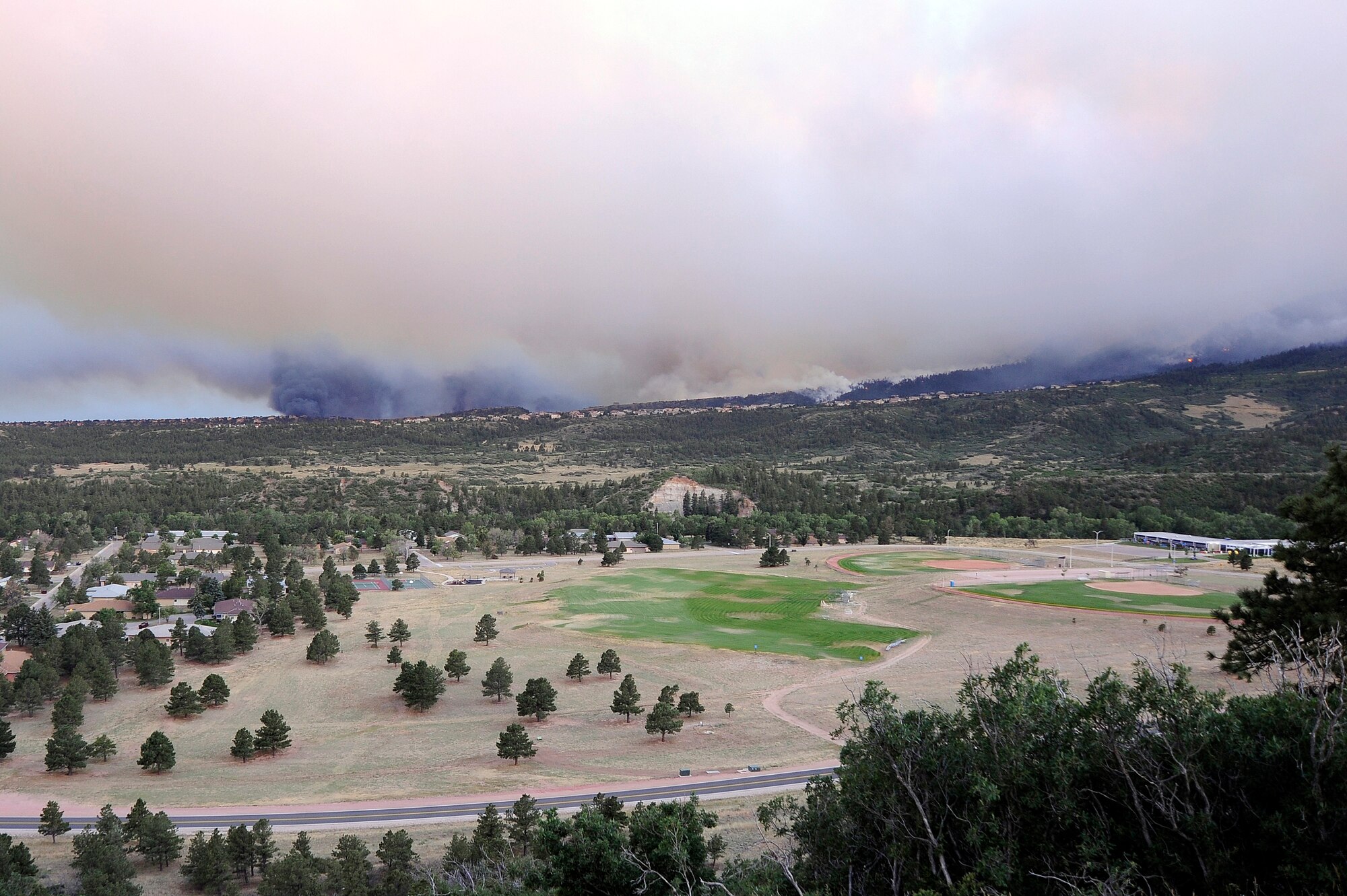 The Waldo Canyon fire burns off the southern border of the U.S. Air Force Academy in Colorado Springs, Colo., June 26, 2012. Mandatory evacuations have been ordered for all housing residents on the Air Force Academy as this fire continues to spread. The Academy's Pine Valley housing area is show in the foreground.  (U.S. Air Force photo/Mike Kaplan)