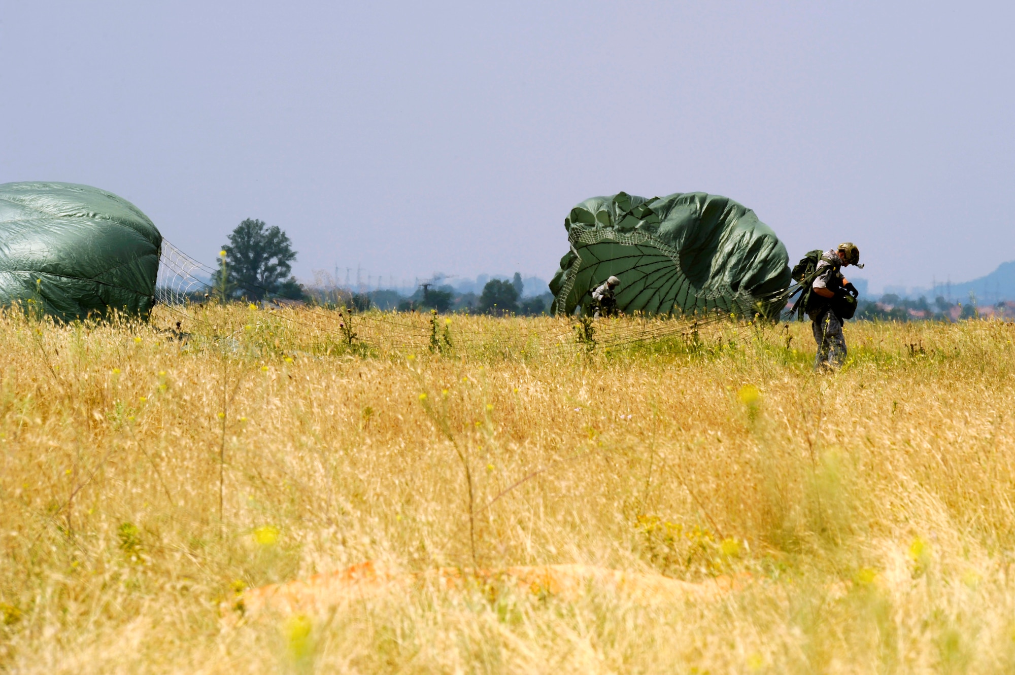 U.S.Air Force 435th Security Forces Squadron members safely land from a static-line jump in Plovdiv, Bulgaria during the Thracian Springs 2012, June 23, 2012. Thracian Spring 2012 is a two week on-site training designed to build partnerships between the U.S. and Bulgarian Air Force. (U.S. Air Force photo/Senior Airman Aaron-Forrest Wainwright)