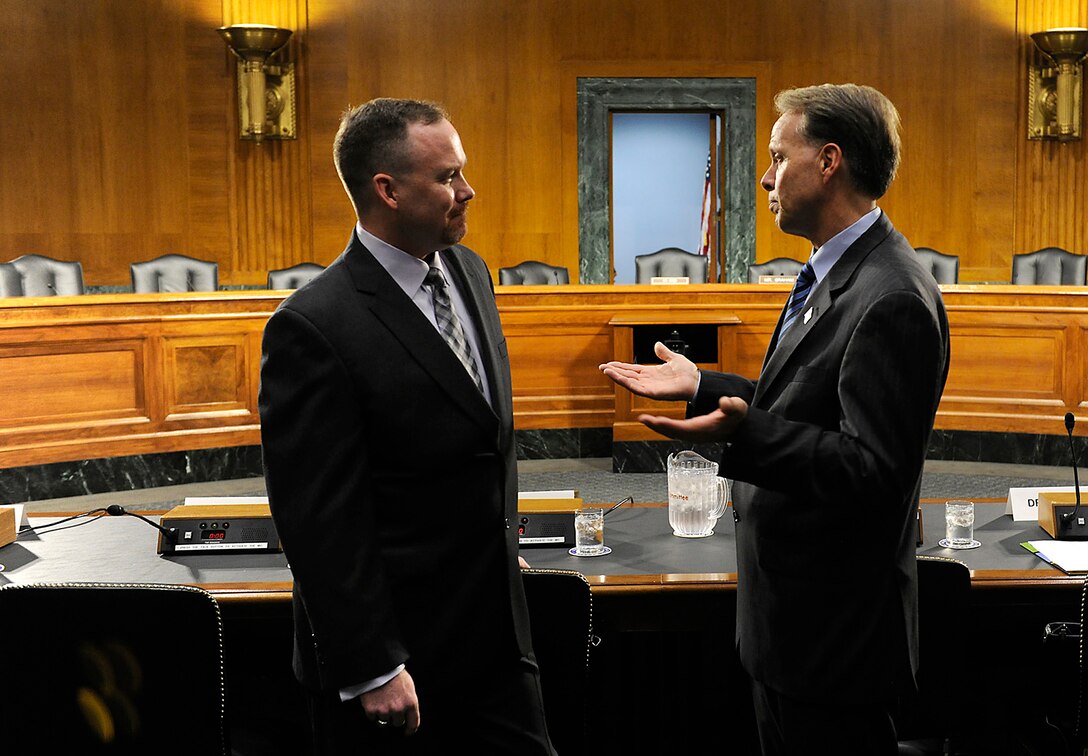Jeremy Hilton and Charles Milam talk prior to a hearing in front of the U.S. Senate Armed Services Subcommittee on Personnel in Washington, D.C., June 21, 2012. Hilton provided testimony on Department of Defense programs and policies in support of military families with special needs. Hilton is the Military Spouse of the Year for 2012 and Milam is the principal director for military community and family policy (U.S. Air Force photo/Scott M. Ash)