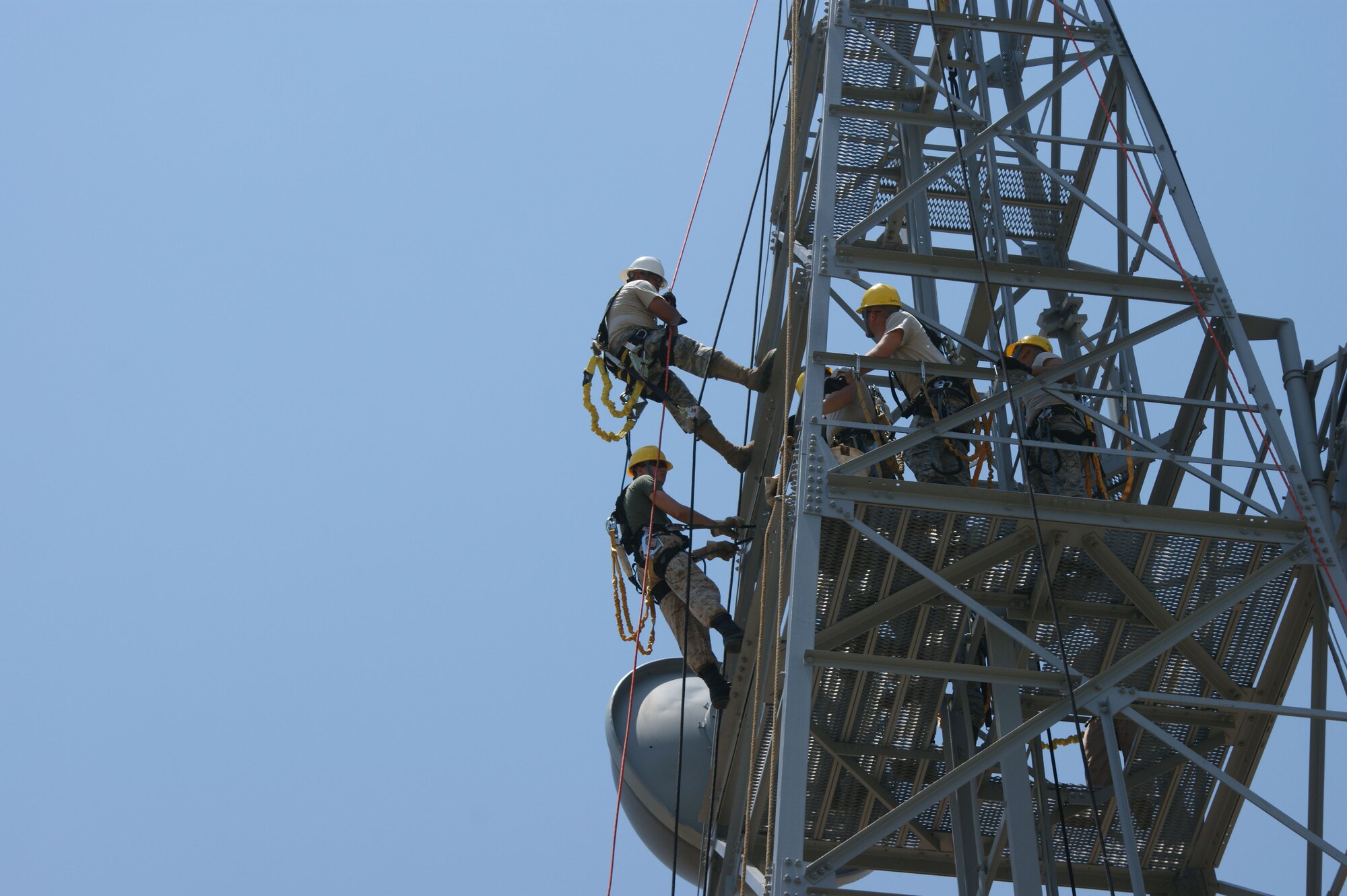 Instructor Staff Sgt. Kristopher Canales (white helmet) and student Lance Cpl. Ryan Shekey (yellow helmet), demonstrate tower rescue procedures to the rest of the class during the Communications Cable and Antenna Systems apprentice course Jun 26, 2012 at Sheppard Air Force Base, Texas.   Students train on pole climbing, installing and terminating commercial fiber and copper cable, splicing fiber and certification testing during the course.  (U.S. Air Force photo/Dan Hawkins)