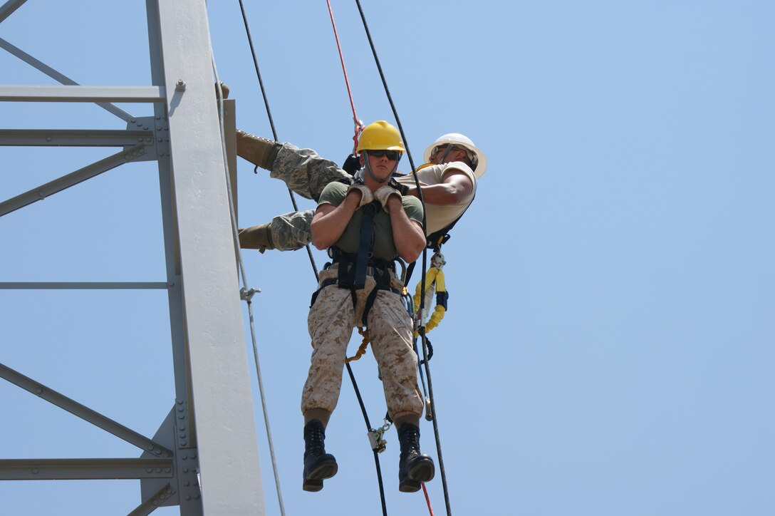 Instructor Staff Sgt. Kristopher Canales (white helmet) and student Lance Cpl. Ryan Shekey (yellow helmet), work through tower rescue procedures during the Communications Cable and Antenna Systems apprentice course Jun 26, 2012 at Sheppard Air Force Base, Texas.   Students are certified as fiber optics installers by the Electronic Technicians Association during the course.  (U.S. Air Force photo/Dan Hawkins)