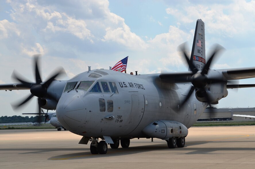 Capt. Christopher Meyer holds an American flag as the C-27J taxis to a stop.The Maryland Air National Guard’s 135th Airlift Squadron returned to Warfield Air National Base on June 25, from a deployment to Afghanistan supporting Operation Enduring Freedom to a crowd of family members and well wishers happy to see them return. The unit's C-27Js were deployed since April. (National Guard photo by Tech. Sgt. David Speicher)