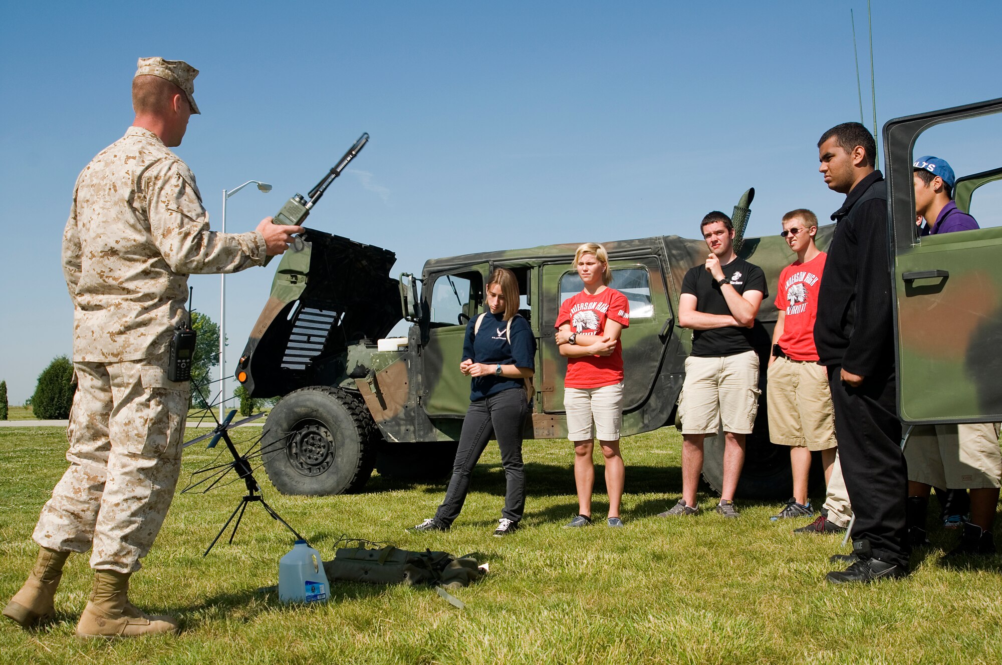 GRISSOM AIR RESERVE BASE, Ind. -- Junior ROTC students from Anderson Preparatory Academy, Anderson, Ind., listen to Lance Cpl. William Hogestyn III, a radio operator with Detachment 1, Communications Company, Headquarters and Service Battalion, 4th Marine Logistics Group, as he explains how to use a field radio outside the Marine Corps Reserve Center at Grissom May 23. The students visited the base to learn about the military.