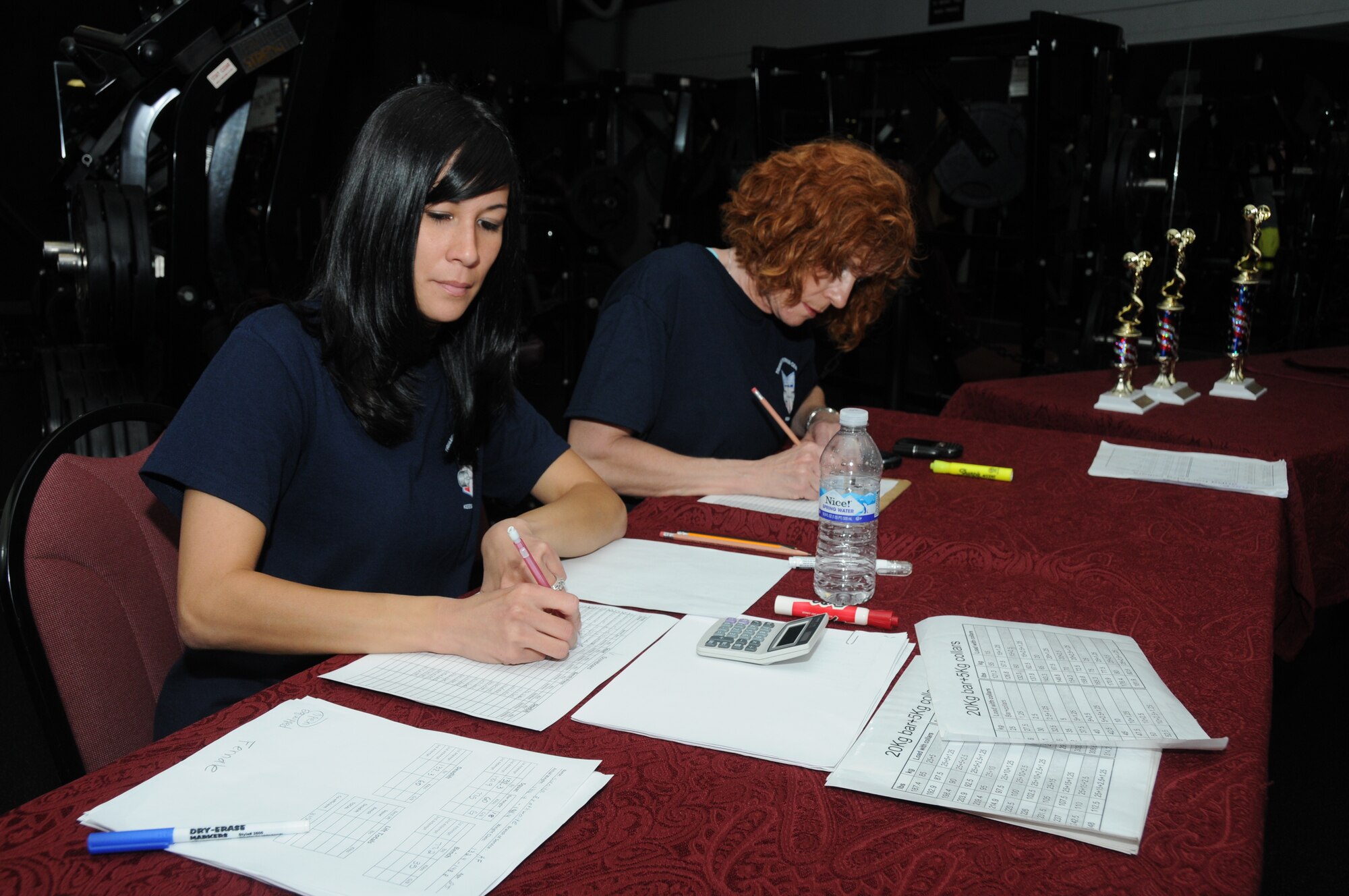 Amanda Rowley and Donna Flynn, CSC, keep track of the 15 competitors’ progress throughout the American Powerlifting Federation event at the Triangle Fitness Center June 22, 2012, Keesler Air Force Base, Miss.  Each participant completed squats, bench presses and dead lifts in four categories — open raw division, equipped division, masters division and women division.  (U.S. Air Force photo by Kemberly Groue)