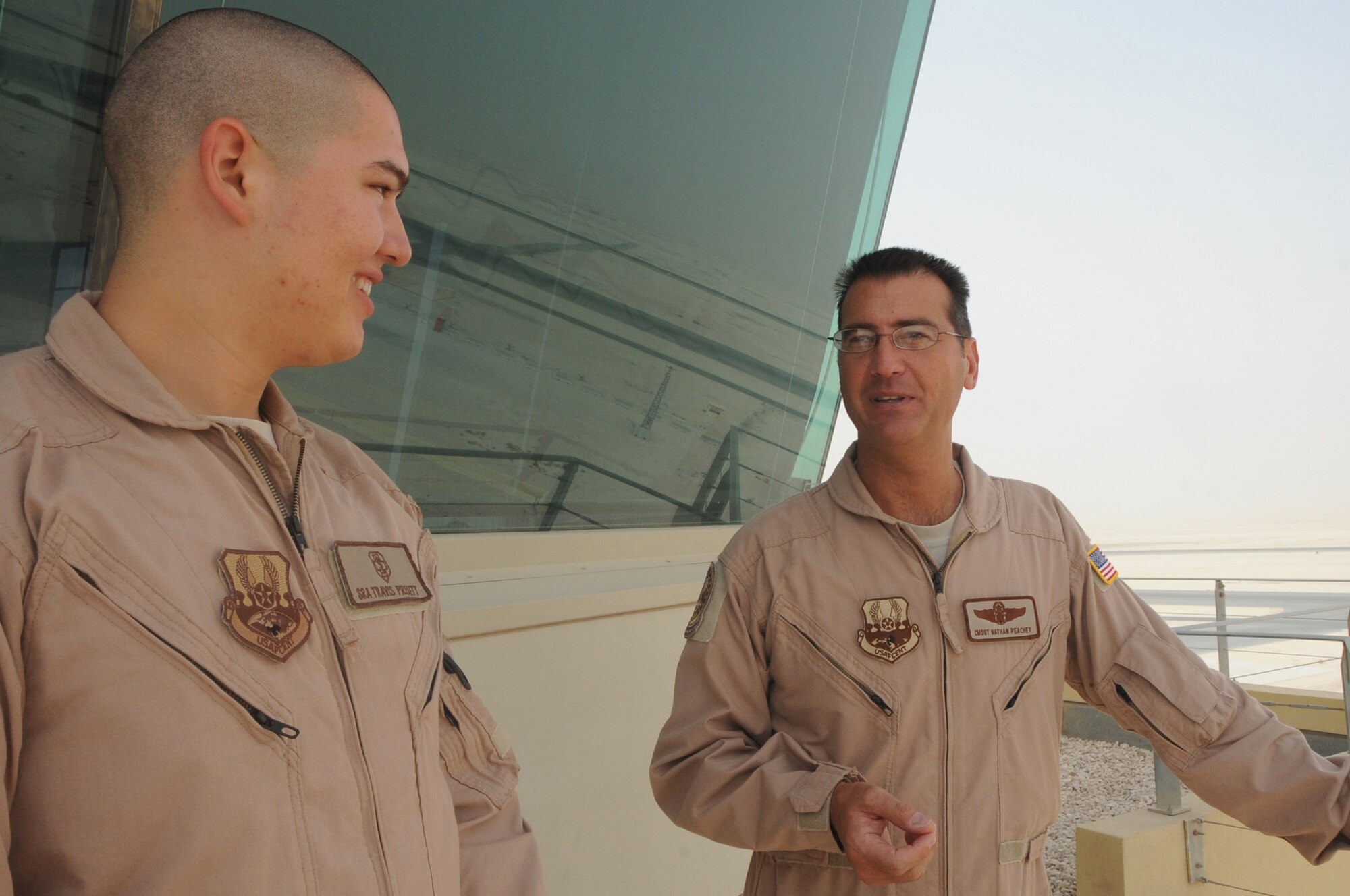 Senior Airman Travis Pruett, left, listens as Chief Master Sgt. Nathan Peachey talks about the 379th Air Expeditionary Operations Group June 22. The two were paired together for “Chief’s Shadow Day.” The goal of the program is to develop and mentor future Air Force leaders. (U.S. Air Force photo/Master Sgt. Ryan Kruse)