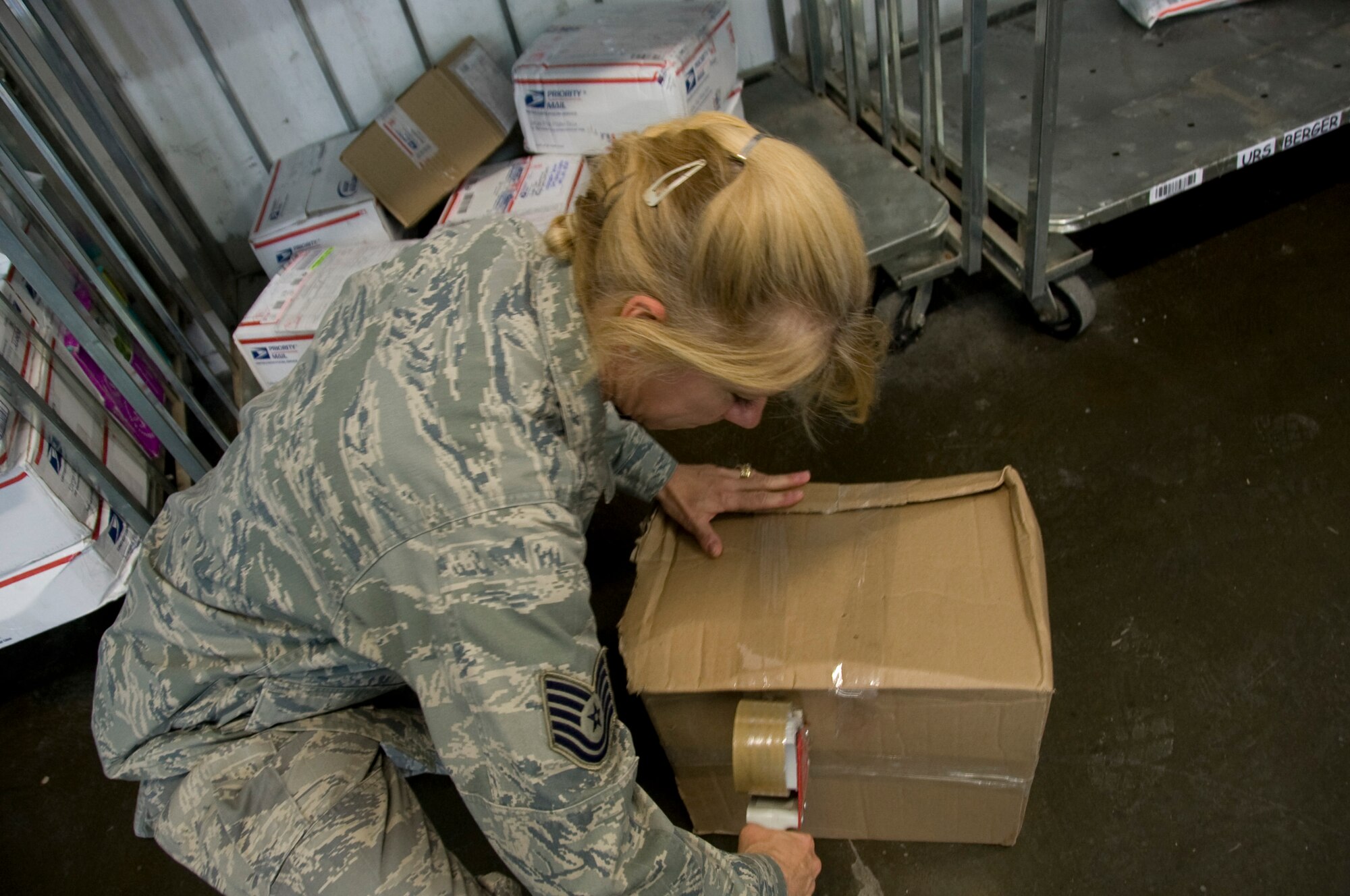 Technical Sgt. Loreen Fetterhoff, 379th ECS official mail manager, reseals a package June 27, 2012 at the Blatchford-Preston Complex Post Office. The post office staff ships between 200 and 300 parcels every day. (U.S. Air Force photo/Senior Airman Bryan Swink)