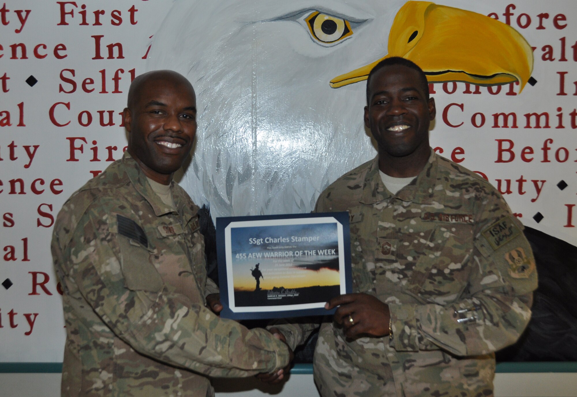 Staff Sgt. Charles Stamper (left), member of the 455th Air Expeditionary Wing Religious Support Team, receives the Warrior of the Week award from Chief Master Sgt. Marcus Snoddy, 455th Air Expeditionary Wing Command Chief Master Sgt., at Bagram Airfield, Afghanistan, June 27, 2012. Stamper supports the Chaplain staff during night shift, providing spiritual care to hospital personnel and hundreds of incoming and outgoing patients monthly. He provided comfort to hospital staff through 100 traumas in his first month as a staff member. According to Chaplain leadership, Stamper has made a special effort to bring a smile to the face of more than 150 patients he has visited – even through their most trying times. (U.S. Air Force photo/TSgt. Shawn David McCowan)