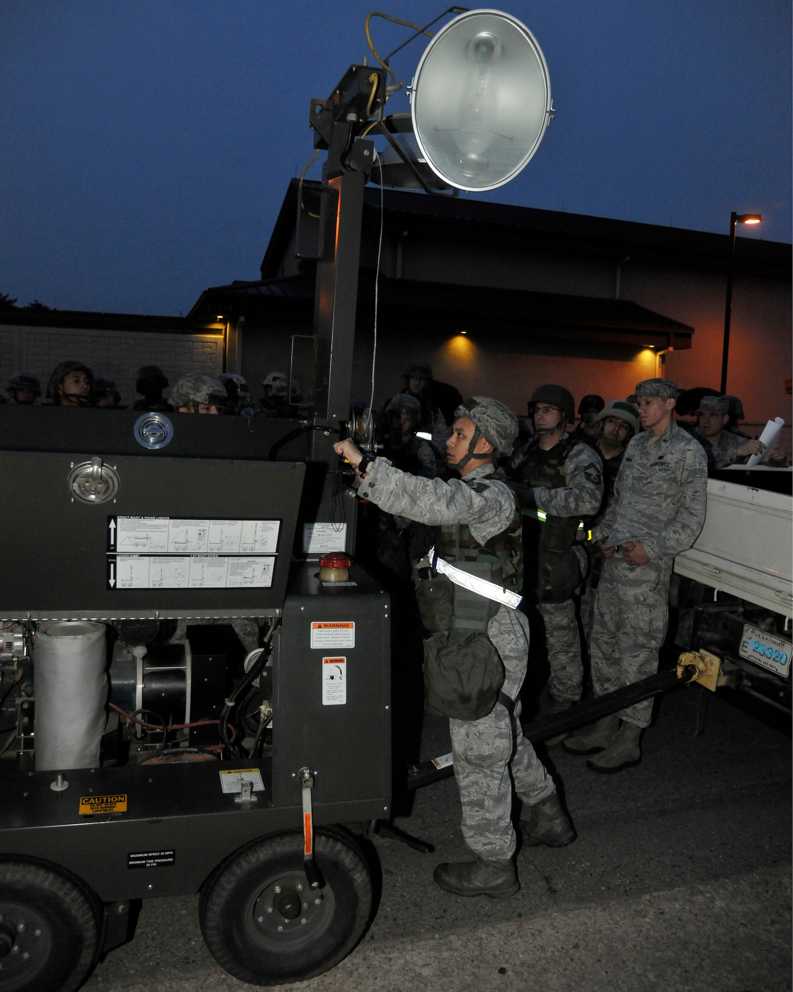 Tech. Sgt. Peter Saechao, left, 8th Civil Engineer Squadron power production craftsman, demonstrates how to set up a light-all during night operations at Kunsan Air Base, Republic of Korea, June 21, 2012. The light-alls are used for high traffic and security areas that need lighting during blackouts or night operations. (U.S. Air Force photo/Senior Airman Marcus Morris)