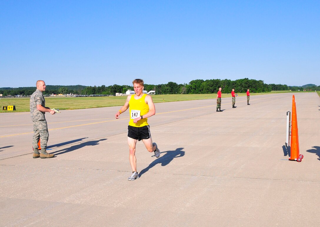 The winner of the Volk 5K run crosses the finish line.  Photo by Joe Oliva, Jetpix.com.