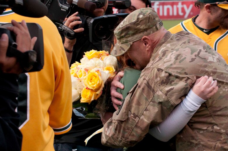 OAKLAND, Calif. — Allie Pearce gets a hug from her dad, Army Specialist Scott Pearce, before the Oakland Athletics game against the San Francisco Giants at O.co Coliseum here, June 22, 2012.