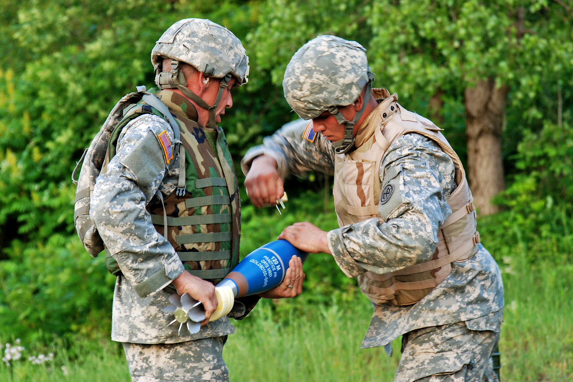 Soldiers prepare a 120mm mortar round for firing during a weapon system qualification on Fort