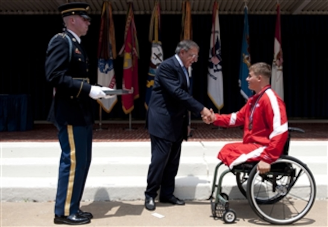 Secretary of Defense Leon E. Panetta congratulates U.S. Marine Corps Lance Cpl. Ronald Sullivan at the 2012 Warrior Games Recognition Ceremony in the Pentagon Center Courtyard in Arlington, Va., on June 25, 2012.  