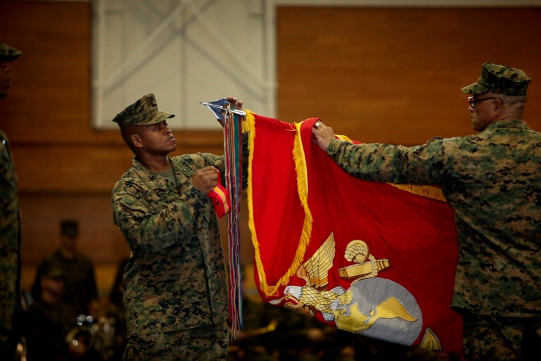 Brig. Gen. Craig Q. Timberlake attaches a battle streamer to the 3rd Marine Expeditionary Brigade unit colors signifying the reactivation of the brigade. The MEB provides supported combat commanders with a scalable emergency response capability throughout the Asia-Pacific region. The Okinawa-based MEB is responsible for providing this capability throughout the Asia-Pacific region. Timberlake is the commanding general of the 3rd MEB and deputy commanding general for III Marine Expeditionary Force. (Photo by: Cpl. Patricia D. Lockhart)