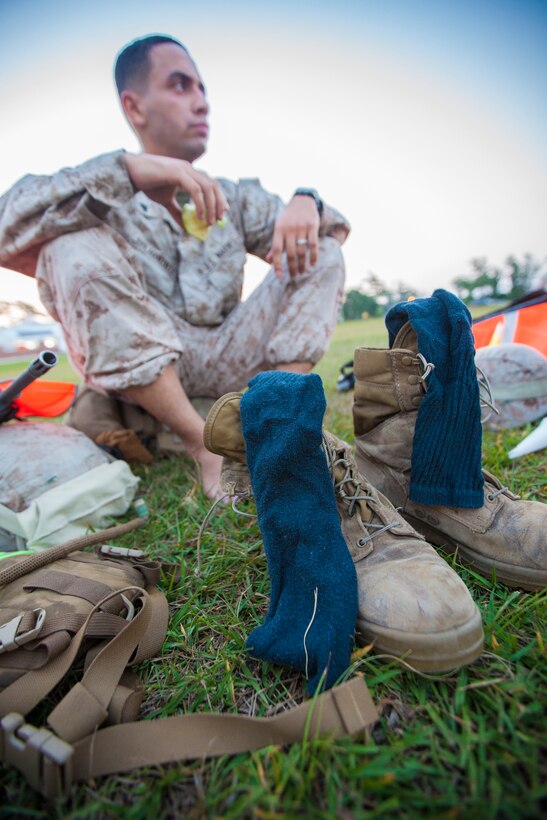 Cpl. Leonardo Avila-Gonzalez, a 26th Marine Expeditionary Unit (MEU) Command Element radio operator, airs his feet out and dries his socks on his boots during a six-mile hike on Camp Lejeune, N.C., June 29, 2012. The hike was part of the 26th MEU CE's physical training schedule, which is used to enhance the camaraderie among the personnel in the unit. (U.S. Marine Corps photo by Cpl. Christopher Q. Stone/Released)