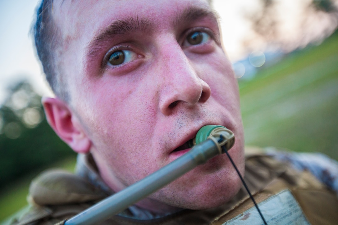 Cpl. John Squires, a 26th Marine Expeditionary Unit (MEU) Command Element radio operator, takes a sip of water from his camelback during a six-mile hike on Camp Lejeune, N.C., June 29, 2012. The hike was part of the 26th MEU CE's physical training schedule, which is used to enhance the camaraderie among the personnel in the unit. (U.S. Marine Corps photo by Cpl. Christopher Q. Stone/Released) ::r::::n::::r::::n::