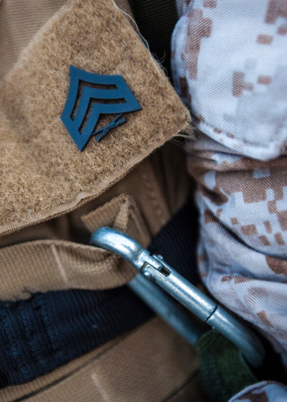 Sgt. Christopher Shelby, a 26th Marine Expeditionary Unit (MEU) Command Element embark noncommissioned officer, pins his sergeant chevron onto his flak jacket during a six-mile hike on Camp Lejeune, N.C., June 29, 2012. The hike was part of the 26th MEU CE's physical training schedule, which is used to enhance the camaraderie among the personnel in the unit. (U.S. Marine Corps photo by Cpl. Christopher Q. Stone/Released) ::r::::n::::r::::n::