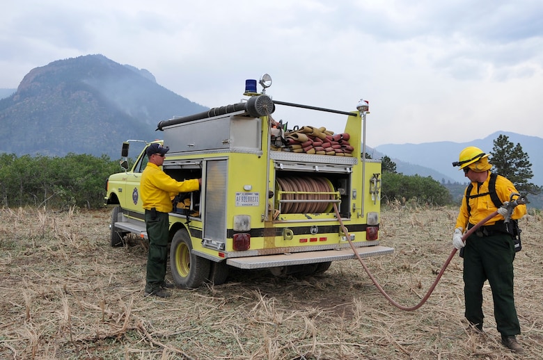 Dennis Lieneke, and Matt Backeberg, pull fire lines off a truck in preparation for spot fires at the U.S. Air Force Academy, Colo., June 28. Both are firefighters assigned to Cheyenne Mountain Air Force Station, Colo. The Waldo Canyon fire has destroyed more than 18,000 acres in the Colorado Springs area. (U.S. Air Force photo by Staff Sgt. Christopher Boitz)