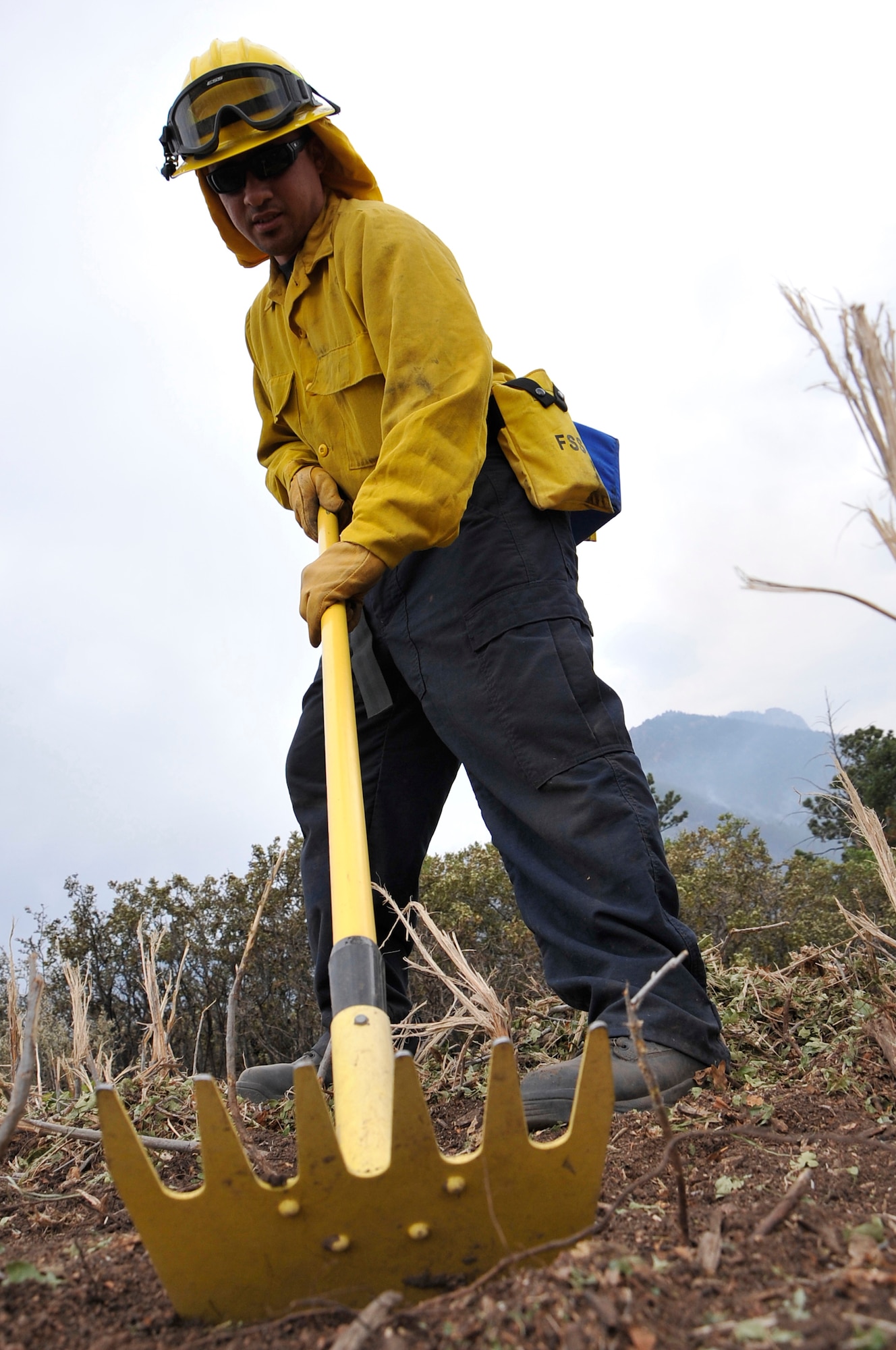 Bobby Garza, a fire fighter assigned to Buckley Air Force Base, Colo., cuts a line to create a firebreak to prevent fires from jumping into the U.S. Air Force Academy, Colo., June 28. The Waldo Canyon fire has destroyed more than 18,000 acres in the Colorado Springs area. (U.S. Air Force photo by Staff Sgt. Christopher Boitz)