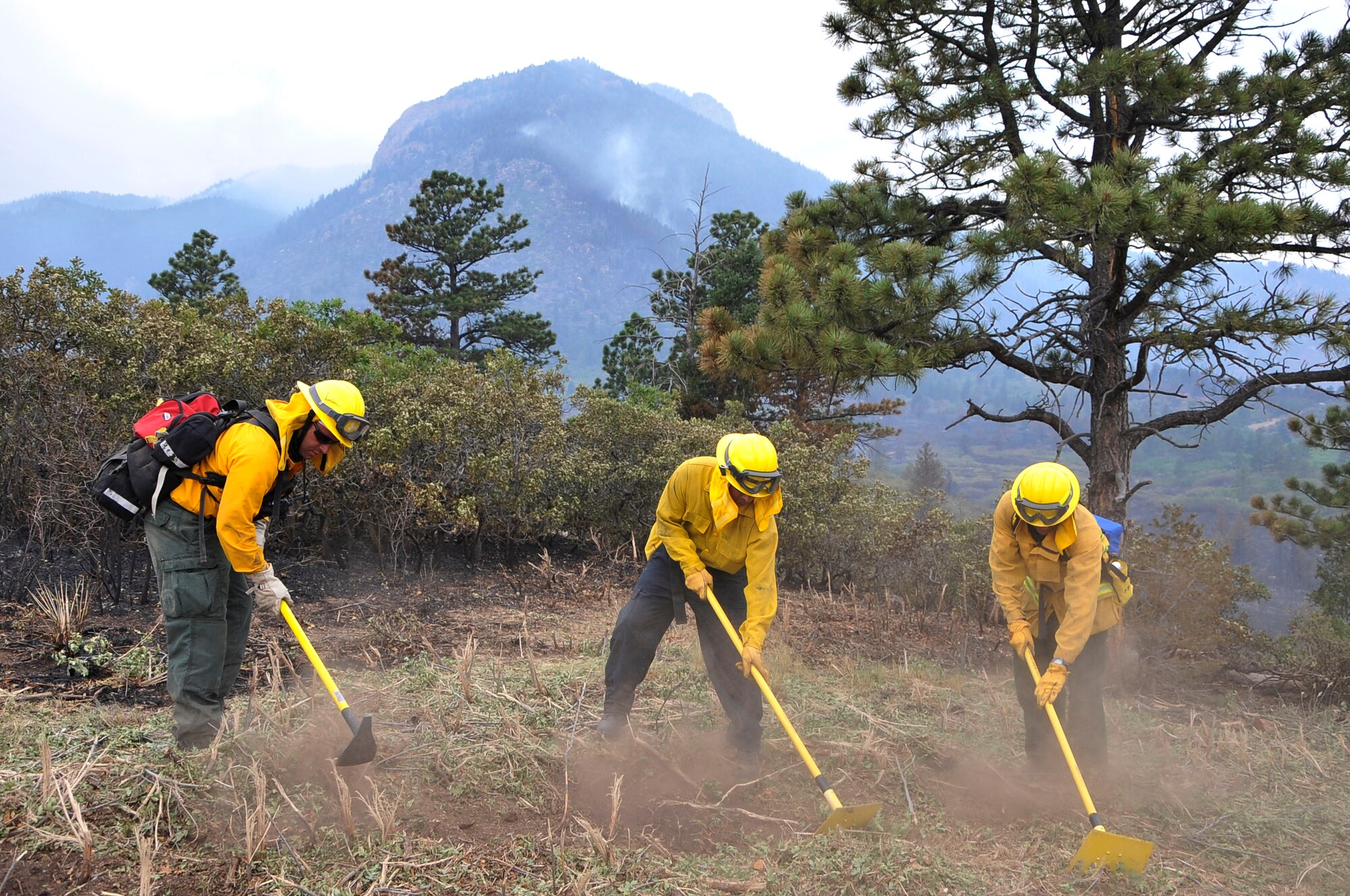 Tech Sgt. Jason Linta, Bobby Garza, and Dean Prestia cut lines to create a firebreak to prevent fires from jumping at the U.S. Air Force Academy, Colo., June 28. Sergeant Linta is a firefighter assigned to the Air Force Academy and Garza and Prestia are firefighters assigned to Buckley Air Force Base, Colo. The Waldo Canyon fire has destroyed more than 18,000 acres in the Colorado Springs area. (U.S. Air Force photo by Staff Sgt. Christopher Boitz)