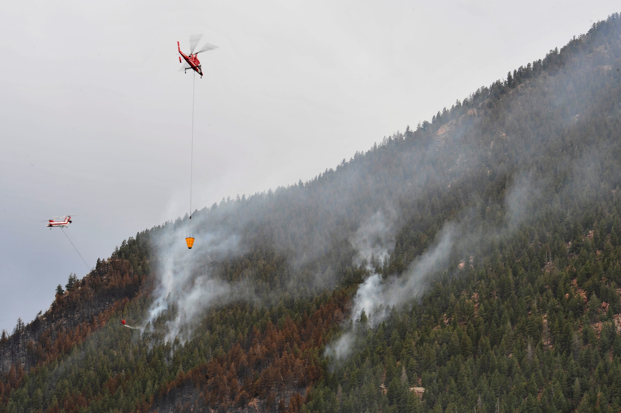 Helicopters dump water on the Waldo Canyon Fire that has spread to the outskirts of the Air Force Academy, Colo., June 28. The Waldo Canyon fire has destroyed more than 18,000 acres in the Colorado Springs area. (U.S. Air Force photo by Staff Sgt. Christopher Boitz)