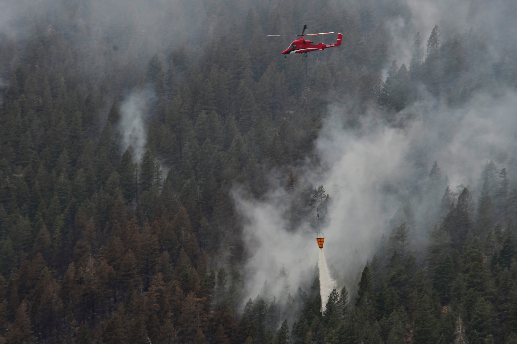 A helicopter dumps water on the Waldo Canyon Fire that has spread to the outskirts of the Air Force Academy, Colo., June 28. The Waldo Canyon fire has destroyed over 18,000 acres in the Colorado Springs area. (U.S. Air Force photo by Staff Sgt. Christopher Boitz)