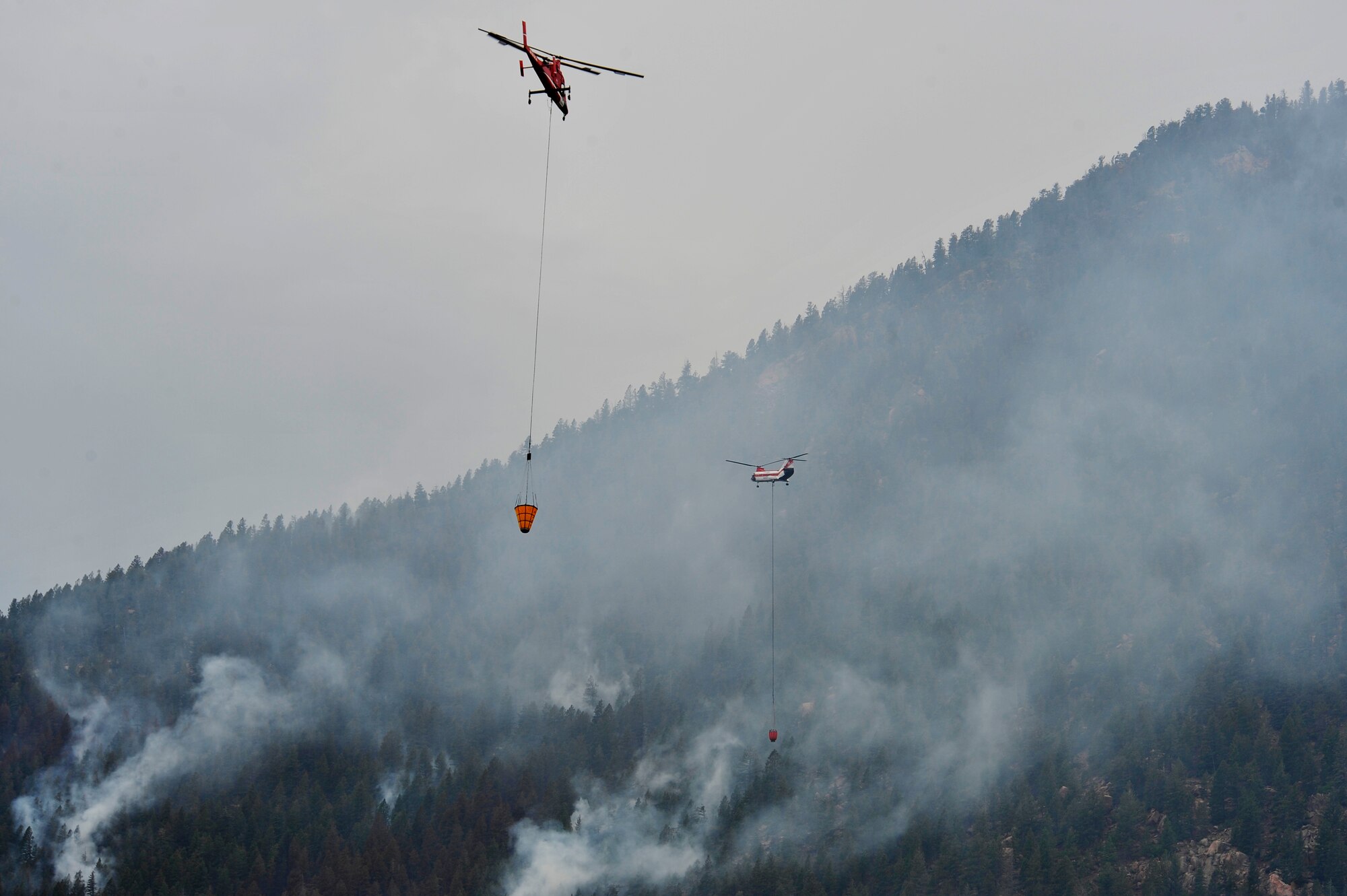 Helicopters dump water on the Waldo Canyon Fire that has spread to the outskirts of the Air Force Academy, Colo., June 28. The Waldo Canyon fire has destroyed over 18,000 acres in the Colorado Springs area. (U.S. Air Force photo by Staff Sgt. Christopher Boitz)