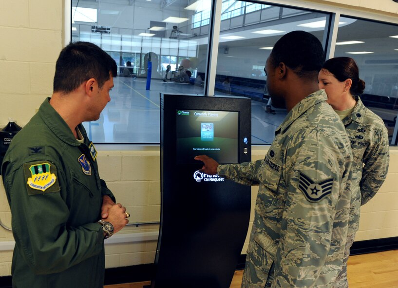 Staff Sgt. Randell Perrio, 2nd Force Support Squadron, shows Col. Andrew Gebara, 2nd Bomb Wing commander, how the Fitness on Request kiosk works during the kiosk's grand opening at the Fitness Center on Barksdale Air Force Base, La., June 28. Due to the complexity of the system, the kiosk must be operated by Fitness Center staff. (U.S. Air Force photo/Airman 1st Class Micaiah Anthony)(RELEASED)

