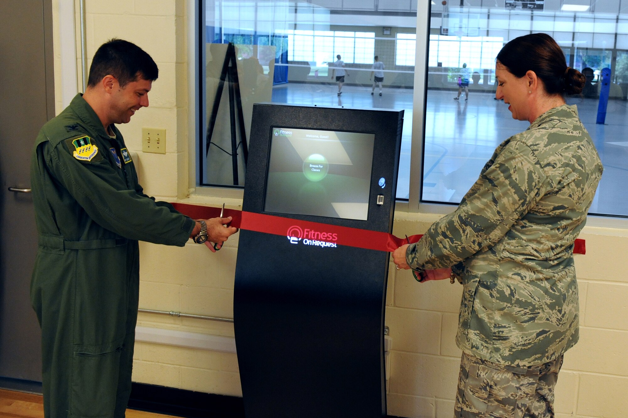Col. Andrew Gebara, 2nd Bomb Wing commander, and Lt. Col. Diane Benavidez, 2nd Force Support Squadron commander, cut the ribbon for the Fitness on Request kiosk during its grand opening at the Fitness Center on Barksdale Air Force Base, La., June 28. The new kiosk offers stomp, kinetics, fusion, spin and kick boxing classes for Airmen and their families to use. The kiosk is located in the aerobics room of the base Fitness Center and can be used any time the room is not occupied by a class. (U.S. Air Force photo/Airman 1st Class Micaiah Anthony)(RELEASED)