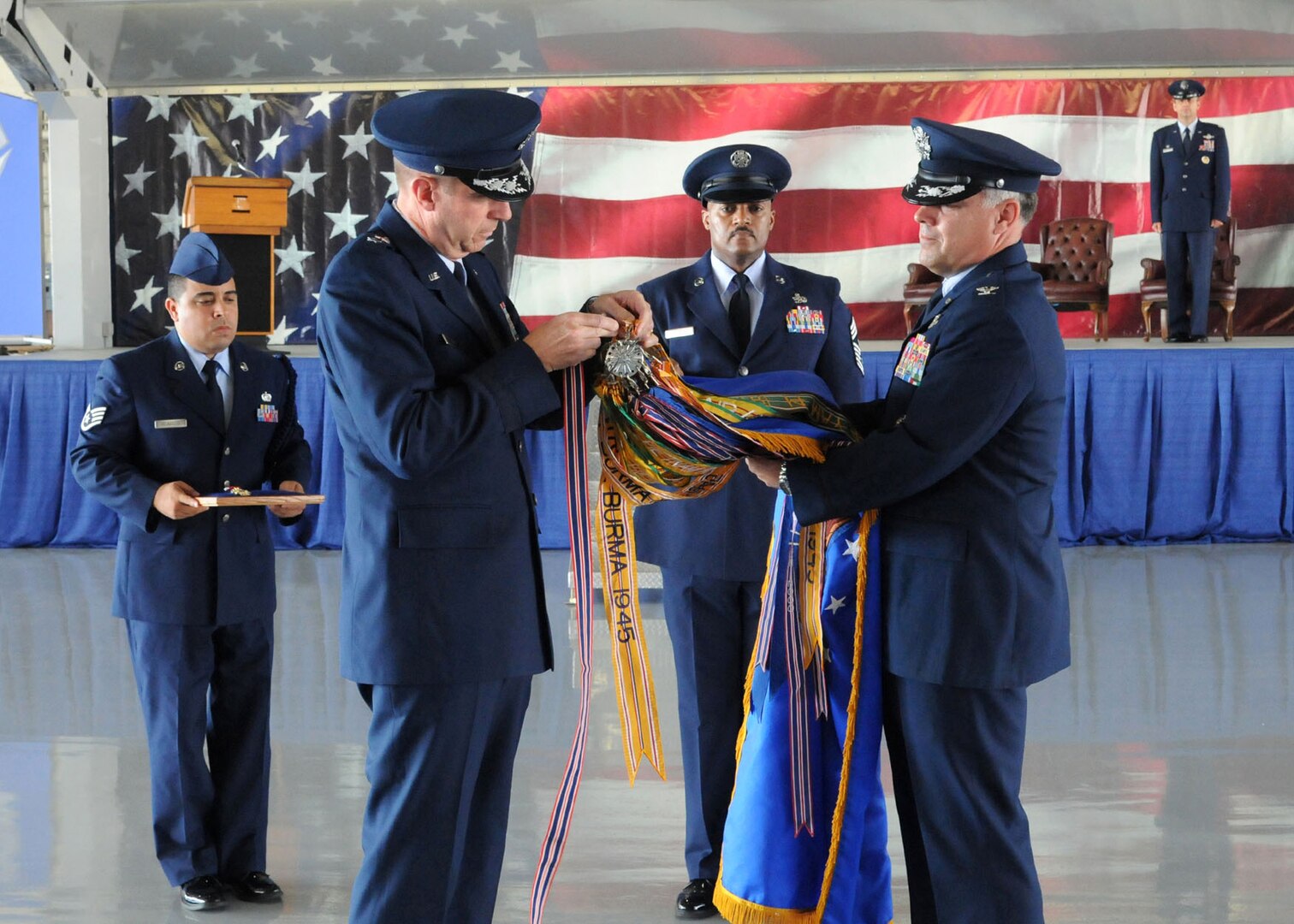 Maj. Gen. Mark Solo, 19th Air Force commander, assists Col. Richard Murphy in placing the Air Force Outstanding Unit Award streamer on the 12th Flying Training Wing flag during Murphy's change of command ceremony at Joint Base San Antonio-Randolph, Texas, June 28. Murphy relinquished command to Col. Gerald Goodfellow who was previously the vice commander for the 7th Bomb Wing at Dyess Air Force Base, Texas. (U.S. Air Force photo by Melissa Peterson)