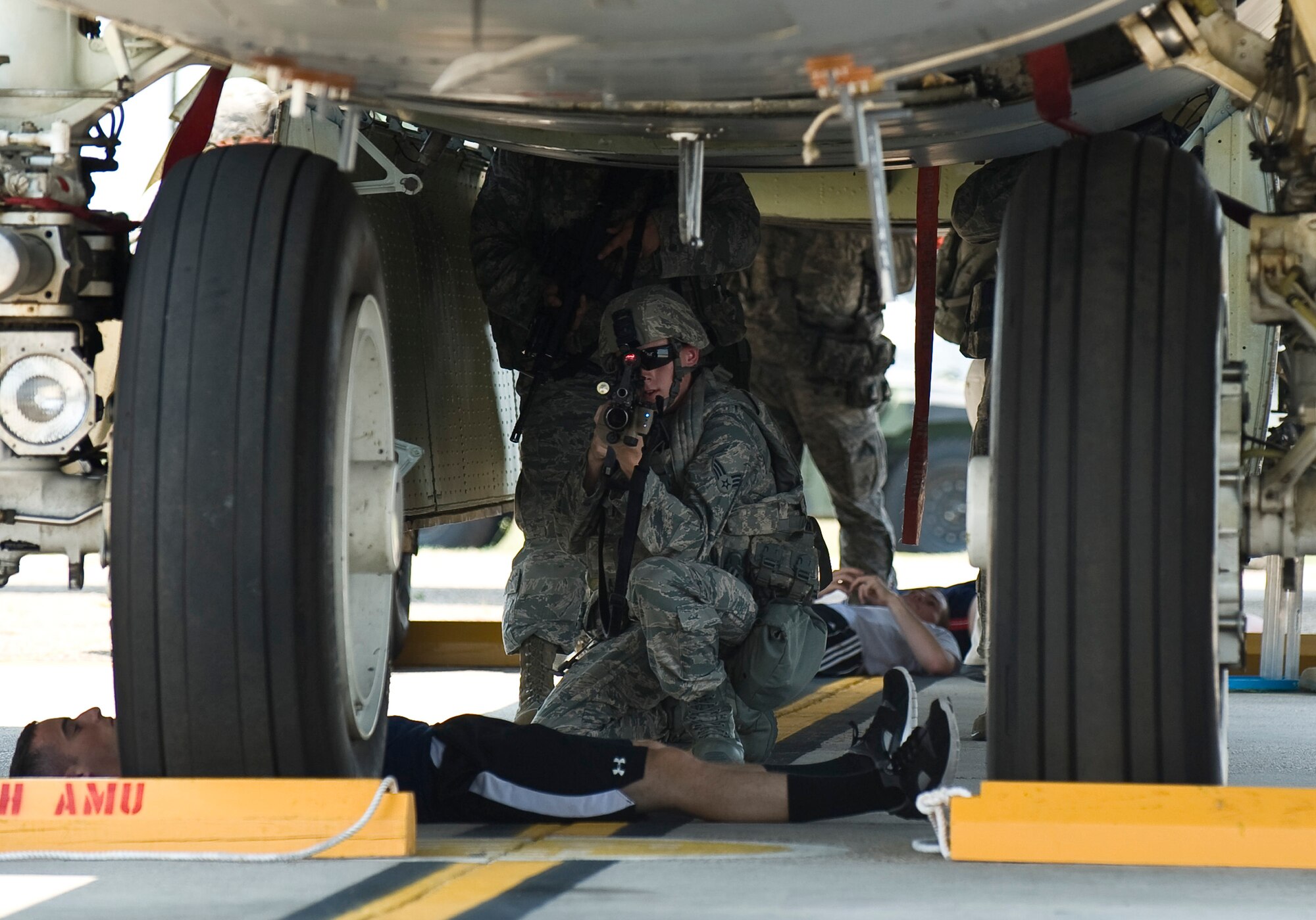 A 2nd Security Forces Squadron Airman provides cover for teammates under a B-52H Stratofortress during a training scenario at Barksdale Air Force Base, La., June 26. This scenario, part of a Nuclear Surety Exercise, evaluated the wing's ability to defend and recover an aircraft loaded with simulated strategic weapons. (U.S. Air Force photo/Staff Sgt. Chad Warren)(RELEASED)