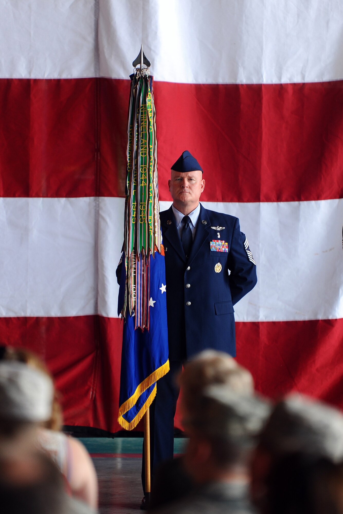 Chief Master Sgt. William W. Thomaston, 55th Wing command chief, holds the ceremonial guidon at the 55th Wing change of command ceremony held at the Bennie Davis Maintenance Facility June 28 on Offutt Air Force Base, Neb. The senior enlisted person holds the guidon until it is passed to the presiding officer signifying a relinquishment of command then handed to the incoming commander who assumes command.  (U.S. Air Force Photo by Josh Plueger/Released)