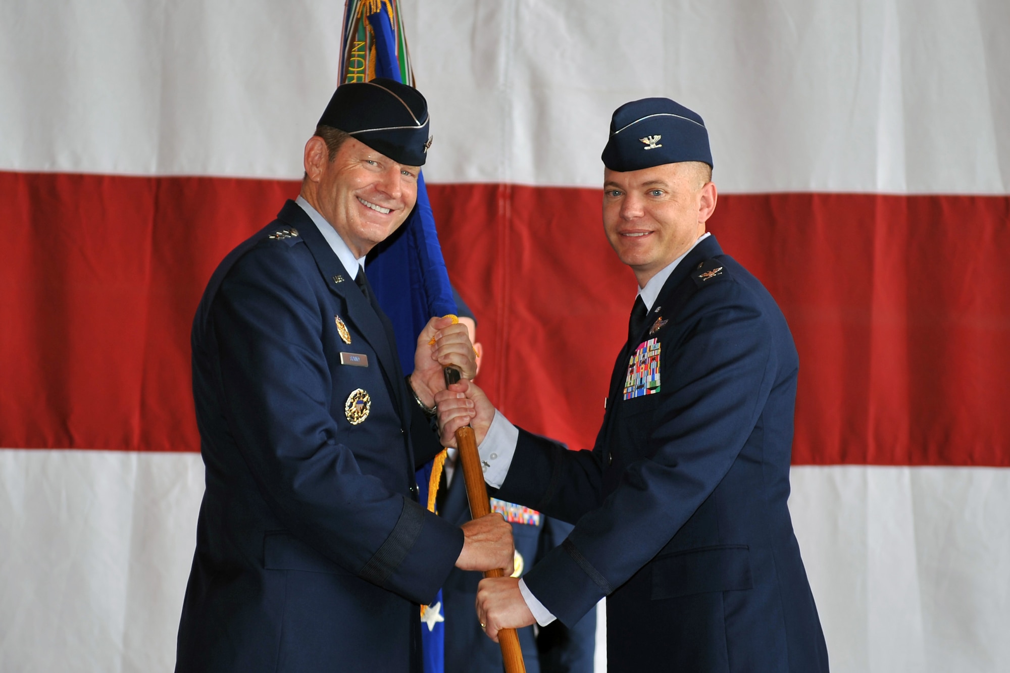U.S. Air Force Lt. Gen. Robin Rand, 12th Air Force commander, presents the 55th Wing guidon to Col. John T. Rauch, incoming 55th Wing commander, during a formal change of command ceremony in Dock 1 of the Bennie Davis Maintenance Facility June 28 at Offutt Air Force Base, Neb.  Hundreds of Airmen, family and distinguished visitors were in attendance for the change of command to welcome the new commander. (U.S. Air Force photo by Jeff W. Gates/Released)