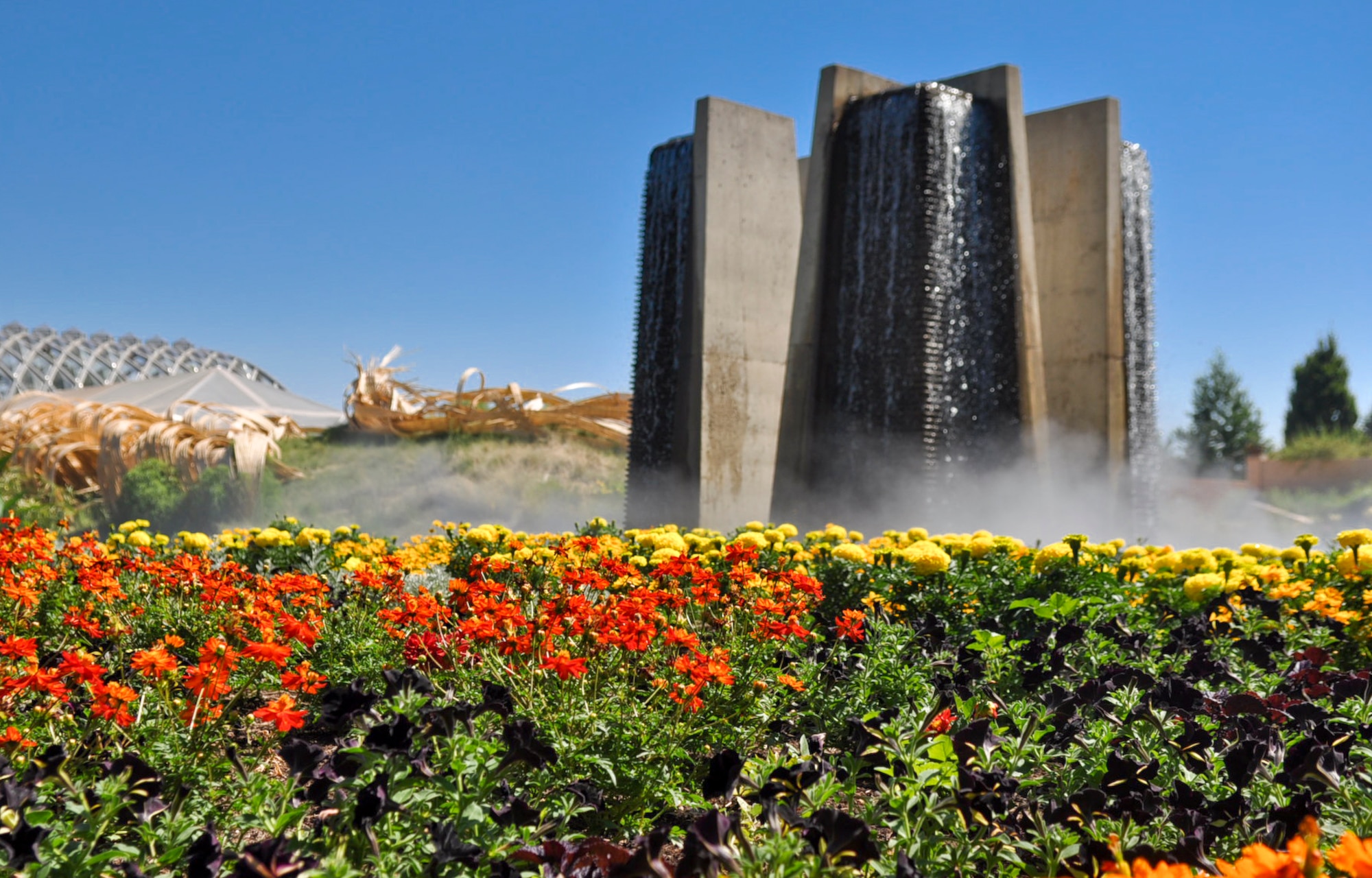 DENVER – The mist from a man-made waterfall rises above a colorful array of flowers at the Denver Botanical Gardens.  The gardens use the time honored traditions of European horticulture merged with a dynamic diversity of plants and design that represent the best in horticultural achievement, according to the official website.  (U.S. Air Force photo by Senior Airman Christopher Gross)